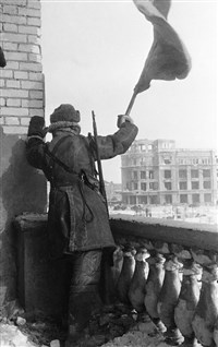 Флаг победы над Сталинградом; видно здание универмага, в подвале которого находился штаб фельдмаршала Паулюса. 1943 год. Снимок А. Кричевского и Наума Грановского [Сталинградская битва]